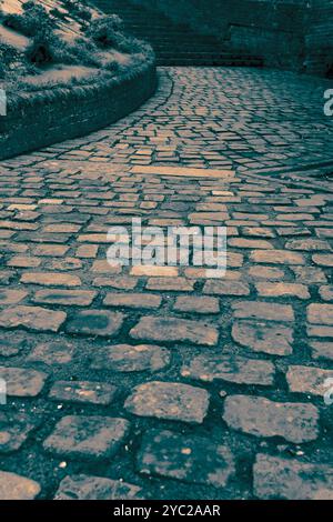 Bloc chemin de pavage trottoir avec marches et mur dans une vieille rue anglaise. Avec nuance de couleur Banque D'Images