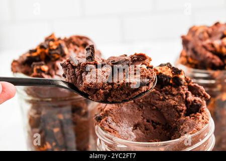 Pâte à brownie non cuit avec biscuits d'Halloween ramassés dans un bocal Banque D'Images