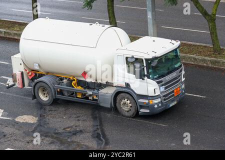 Camion de réservoir de carburant blanc conduisant sur une autoroute, transportant des liquides inflammables à usage industriel Banque D'Images