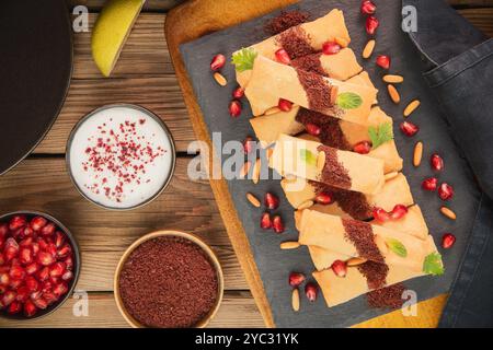 Cuisine arabe ; délicieux croquants 'Musakhan Rolls'. C'est un plat palestinien traditionnel. Servi avec un accompagnement de sauce yaourt et sumac frais. Banque D'Images
