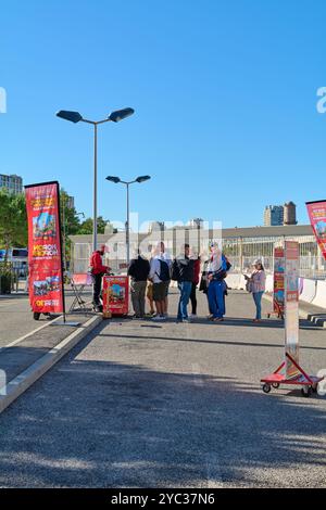 Marseille. France - 21 octobre 2024 : cette photo capture des gens qui font la queue pour acheter des billets pour le bus touristique de Marseille, avec des publicités signalétiques Banque D'Images