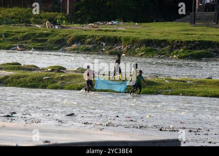 Siliguri, Bengale occidental, Inde. 21 octobre 2024. Les enfants utilisent des moustiquaires lorsqu’ils essaient d’attraper des poissons dans l’eau de la rivière Mahananda à Siliguri. (Crédit image : © Diptendu Dutta/ZUMA Press Wire) USAGE ÉDITORIAL SEULEMENT! Non destiné à UN USAGE commercial ! Banque D'Images