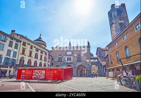 BERGAME, ITALIE - 7 AVRIL 2022 : la Piazza Vecchia médiévale avec restaurants en plein air, Palazzo della Ragione et Palazzo della Podesta avec une grande horloge Banque D'Images