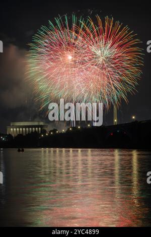 Les feux d'artifice du jour de l'indépendance explosent au-dessus du Lincoln Memorial, du Washongton Monument et du Arlington Memorial Bridge, projetant des relifections colorées Banque D'Images