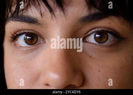 Gros plan des yeux de la femme, exprimant la curiosité et la concentration à la maison Banque D'Images