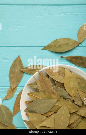 Feuilles de baie en bawl sur fond bleu. Photo verticale. Vue de dessus Banque D'Images