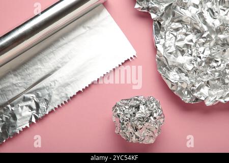 Boule de feuille avec des rouleaux d'aluminium sur fond rose. Vue de dessus Banque D'Images