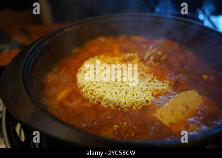 Ajouter les ramen instantanés au bouillon de ragoût kimchi et faire bouillir Banque D'Images