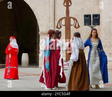 Des filles en costumes traditionnels dansent devant la porte de la ville Arco de Santa María pendant les fiestas El CID Burgos Castille et Léon Espagne Banque D'Images