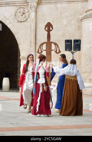 Des filles en costumes traditionnels dansent devant la porte de la ville Arco de Santa María pendant les fiestas El CID Burgos Castille et Léon Espagne Banque D'Images