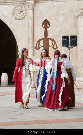 Des filles en costumes traditionnels dansent devant la porte de la ville Arco de Santa María pendant les fiestas El CID Burgos Castille et Léon Espagne Banque D'Images