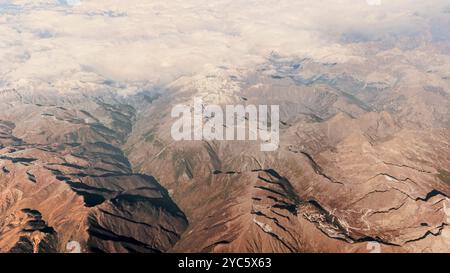 The vastness and grandeur of the snow capped Alps from a high altitude perspective. Rugged mountain peaks extending across the landscape, covered in a Banque D'Images