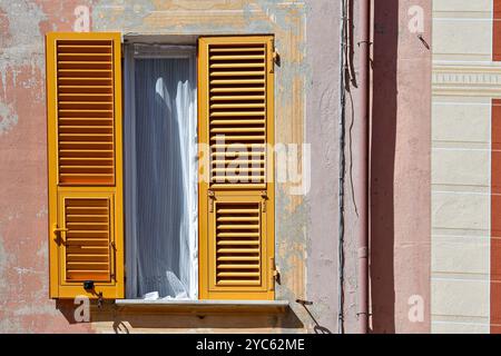 Une fenêtre avec des volets jaunes sur la façade d'une ancienne maison décorée de trompe l'oeil, Sestri Levante, Gênes, Ligurie, Italie Banque D'Images