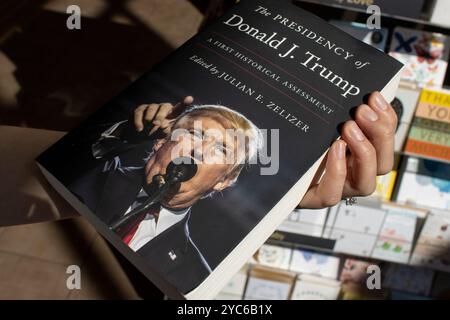 Un lecteur récupère le livre 'la Présidence de Donald J. Trump : a First Historical Assessment' édité par Julian Zelizer sur l'étagère d'une librairie... Banque D'Images