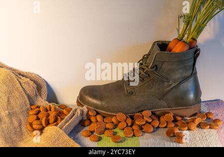 Photo conceptuelle de vacances traditionnelles hollandaises Sinterklaas, sac de jute, pepernoten et carotte dans la chaussure Banque D'Images