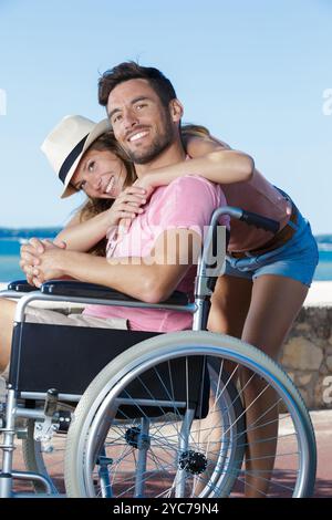 couple heureux avec des problèmes de mobilité sur la plage Banque D'Images