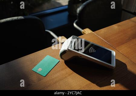 Gros plan du terminal de paiement et de la carte de crédit sur fond de table. Paiement des achats par carte de crédit. E-commerce. Concept commercial Banque D'Images