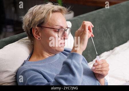 femme se teste pour une nouvelle souche de coronavirus à la maison, test de détection des antigènes covid-19 et des virus de la grippe, diagnostic de la maladie Banque D'Images