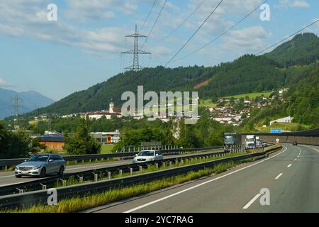 Schlagthurn, Autriche - 13 juin 2023 : un voyage tranquille se déroule le long d'une route sinueuse bordée de verdure luxuriante, révélant un charmant village niché Banque D'Images