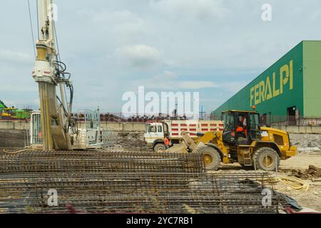 Brescia, Italie - 13 juin 2023 : la machinerie lourde bourdonne d'activité sur un vaste chantier de construction où les travailleurs supervisent les préparations de béton et d'acier Banque D'Images