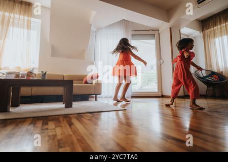 Deux enfants joyeux dansant dans un salon lumineux ensemble Banque D'Images