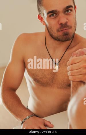 Un athlète déterminé s'engage dans une lutte intense au bras, mettant en valeur sa force et sa compétition dans un cadre de gymnastique Banque D'Images