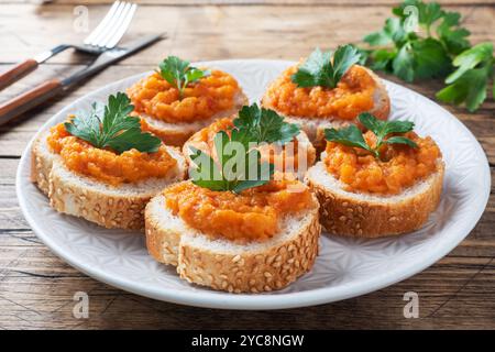 Sandwichs avec pain courgettes caviar tomates oignons. Plats végétariens faits maison. Fond en bois de légumes cuits en conserve Banque D'Images