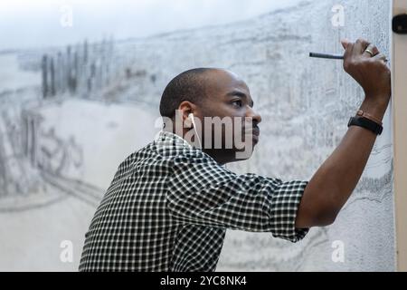 Gros plan sur le célèbre artiste Stephen Wiltshire dessinant le paysage urbain de Singapour à travers son incroyable souvenir photographique d'un seul regard, Banque D'Images