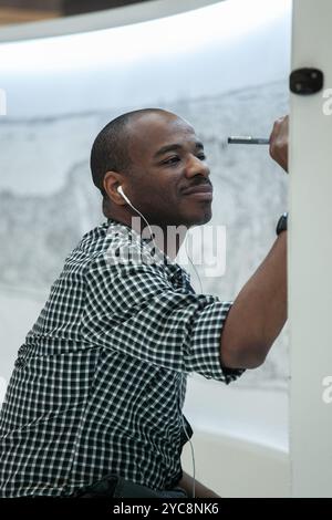 Artiste renommé Stephen Wiltshire souriant tout en dessinant le paysage urbain de Singapour à travers son incroyable mémoire photographique d'un seul regard, Banque D'Images