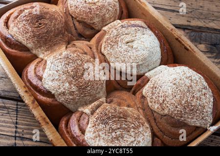 Kanelbulle petits pains à la cannelle avec crème au beurre sur une table en bois rustique. Pâtisseries fraîches faites maison Banque D'Images