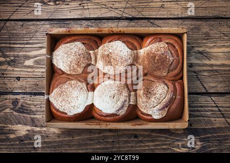 Kanelbulle petits pains à la cannelle avec crème au beurre sur une table en bois rustique. Viennoiseries maison, vue de dessus, espace photocopie. Banque D'Images