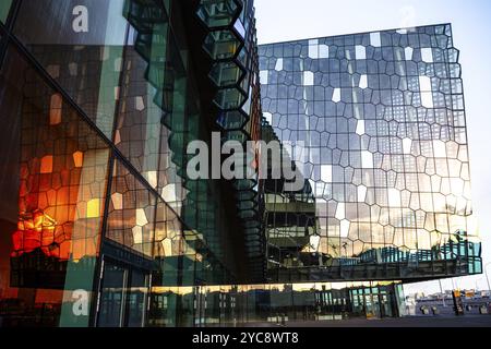 Un bâtiment moderne avec une façade en verre réfléchissant, reflétant le soleil couchant, Harpa concert Hall, Reykjavik, Islande, Europe Banque D'Images