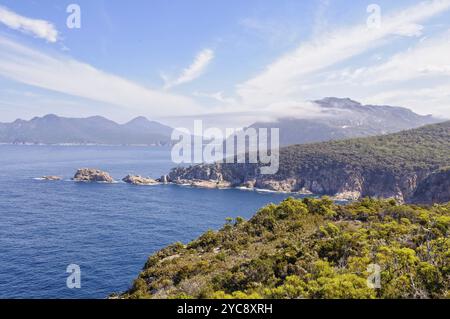 Nuages légers au-dessus de Carp Bay et des Hazards dans le parc national de Freycinet, Tasmanie, Australie, Océanie Banque D'Images