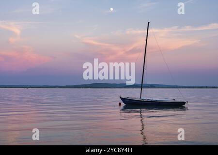 Petit voilier amarré sous la lune sur le lac Balaton, Revfulop, Hongrie, Europe Banque D'Images