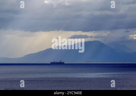 Paysage marin idyllique dans la mer Tyrrhénienne, navire se déplaçant au port de fret de Salerne. Et côte de montagne de Campanie. Vue depuis la côte amalfitaine Banque D'Images