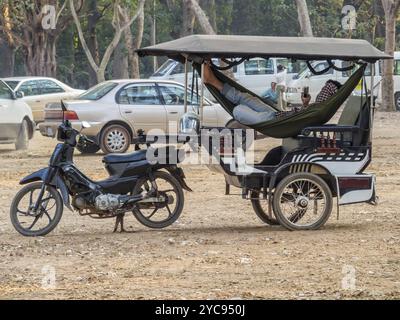 Chauffeur de tuk tuk relaxant attendant ses passagers dans le parking Angkor Wat, Siem Reap, Cambodge, Asie Banque D'Images