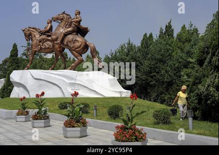 08.08.2012, Pyongyang, Corée du Nord, Asie, Un jardinier travaille dans l'espace vert du Mansudae Art Studio à Pyongyang, où deux statistiques équestres en bronze Banque D'Images