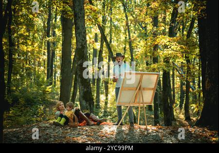 Démarrer une nouvelle photo. Capturez l'instant. Beauté de la nature. Homme barbu femme et fils relaxent la nature automnale. Dessiner de la vie. Artiste peintre en famille Banque D'Images