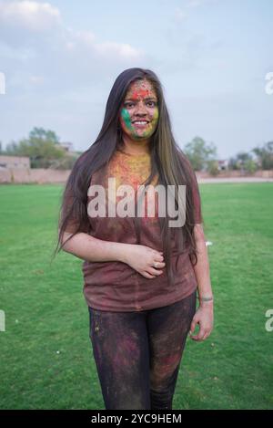 Heureuse jeune femme indienne couverte de poudre colorée ou gulal célébrant le festival de couleurs holi. Culture de l'inde. Banque D'Images