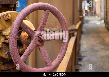 Volant de valve rouillé altéré par les intempéries gros plan sur l'atelier de production pétrochimique industriel hors de propos Banque D'Images