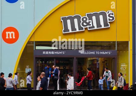 SHANGHAI, CHINE - 22 OCTOBRE 2024 - des piétons passent devant le magasin de chocolat M&M sur la rue piétonne Nanjing Road à Shanghai, Chine, octobre Banque D'Images