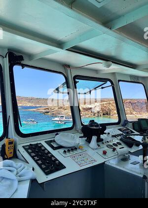 Dans la cabine d'un capitaine sur un bateau de croisière touristique dans le Blue Lagoon sur l'archipel maltais, Malte. Banque D'Images