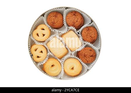 Biscuits sertis dans une boîte en métal. Dessert sucré pour les vacances. Isolé sur fond blanc. Variété de biscuit. Vue de dessus. Banque D'Images