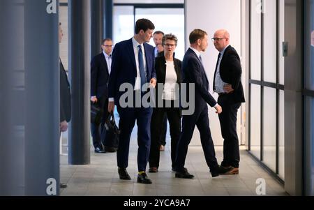 22 octobre 2024, Saxe, Dresde : Conrad Clemens (CDU, g-d), chef de la Chancellerie d'État, Sabine Zimmermann, coprésidente de la BSW Saxe, Michael Kretschmer (CDU), premier ministre de Saxe, et Henning Homann, coprésident du SPD de Saxe, discutent dans le couloir après la première série de pourparlers exploratoires entre la CDU, la BSW et le SPD sur la formation d'un gouvernement d'État en Saxe. L'alliance gouvernementale possible de CDU, BSW et SPD est appelée une mûre parce que le fruit peut être noir, violet ou rouge, selon la façon dont il est mûr. Ce sont les couleurs des trois parties impliquées. Photo : Robert Michael/dpa Banque D'Images