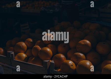 Casse remplie d'orange qui crée une teinte orange. Fruits à l'étal du marché. Photo de haute qualité Banque D'Images