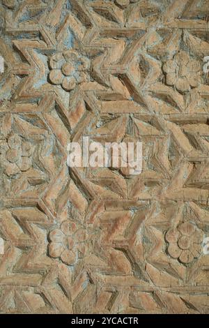 Motif géométrique complexe sculpté dans le bois, avec des motifs floraux et des formes d'étoiles. Le design met en valeur l'artisanat traditionnel, avec un et usé Banque D'Images