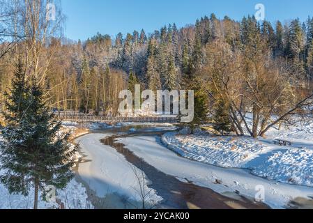 Rivière Amata, pont en bois, forêt neigeuse le jour d'hiver ensoleillé en Lettonie Banque D'Images
