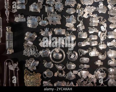 Berkeley Square, Londres, Royaume-Uni. 22 octobre 2024. LAPADA (la plus grande association professionnelle de marchands d'art et d'antiquités au Royaume-Uni) collections d'art et d'antiquités sous un même toit dans une chapiteau décorée, en cours d'exécution du 23-27 octobre à Berkeley Square. Les points forts incluent : argenterie, y compris une collection d'étiquettes de bouteilles de Porto et de vin et de carafes. Crédit : Malcolm Park/Alamy Live News Banque D'Images