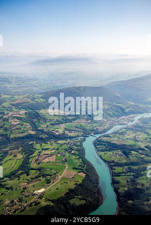 Superbe photo aérienne mettant en valeur les Alpes majestueuses avec une rivière turquoise serpentant à travers des paysages verdoyants sous un ciel bleu clair Banque D'Images