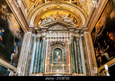 Maître-autel de l'église baroque de Santa Maria della Pace, avec une peinture de la Vierge à l'enfant à Rome, Italie. Banque D'Images